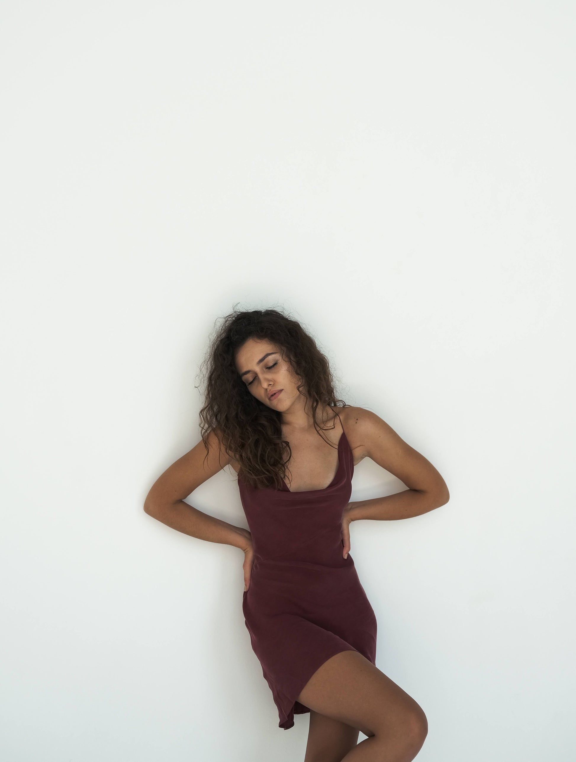 Woman wearing a burgundy dress against a white background