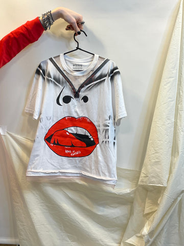 White t-shirt with red lips graphic design held by a person against a white background