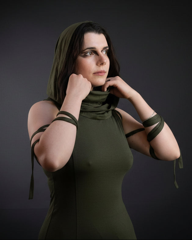 Woman in a green dress with arm straps in a crowded indoor setting