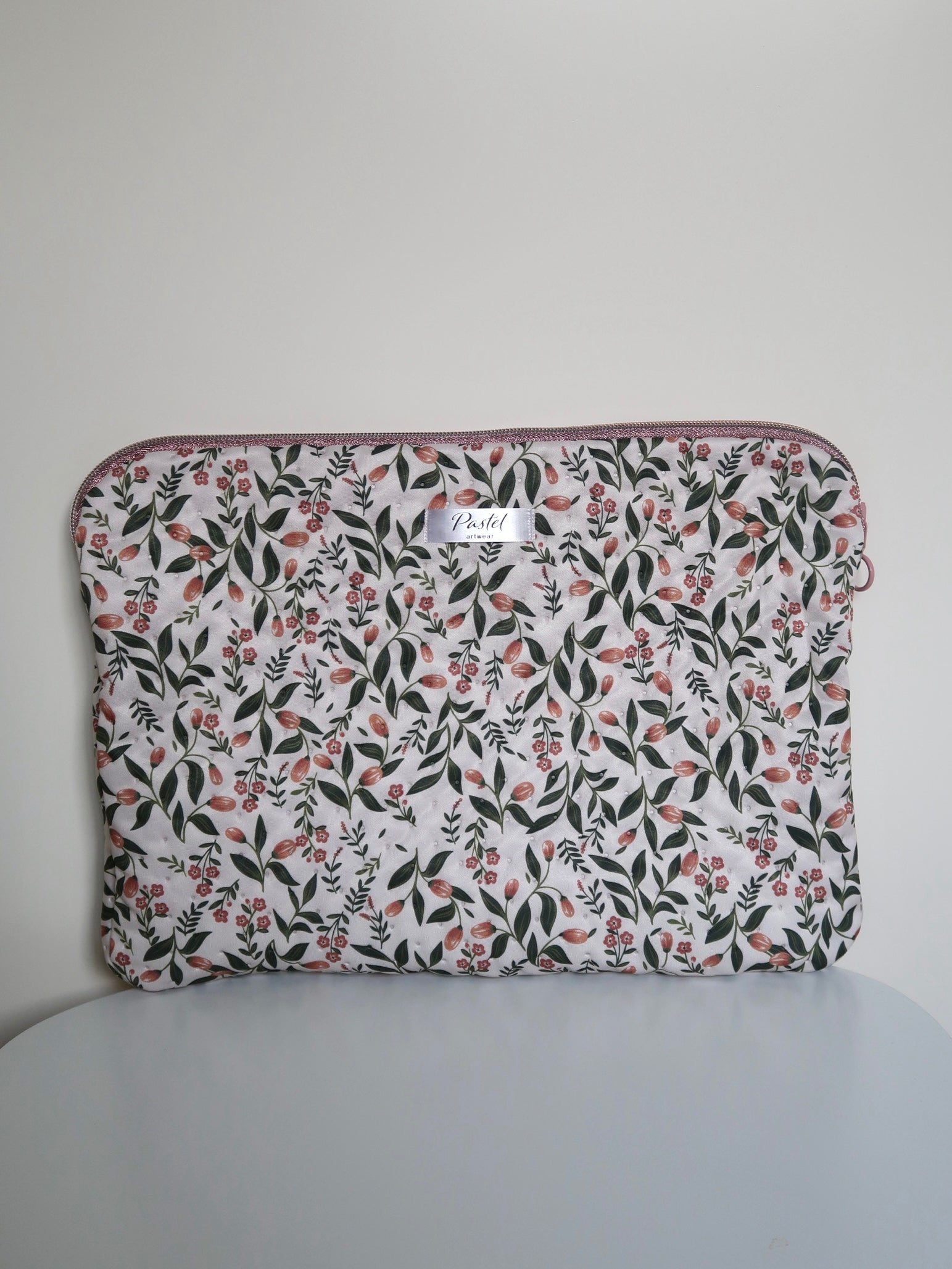 Floral patterned pouch on a gray chair with a plain background